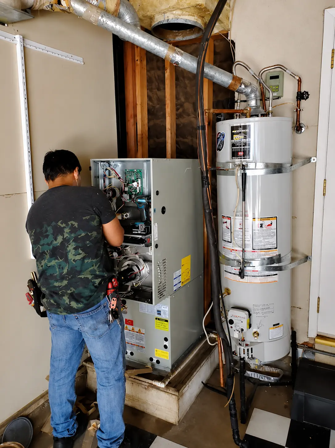 HVAC technician repairing gas furnace in San Jose home